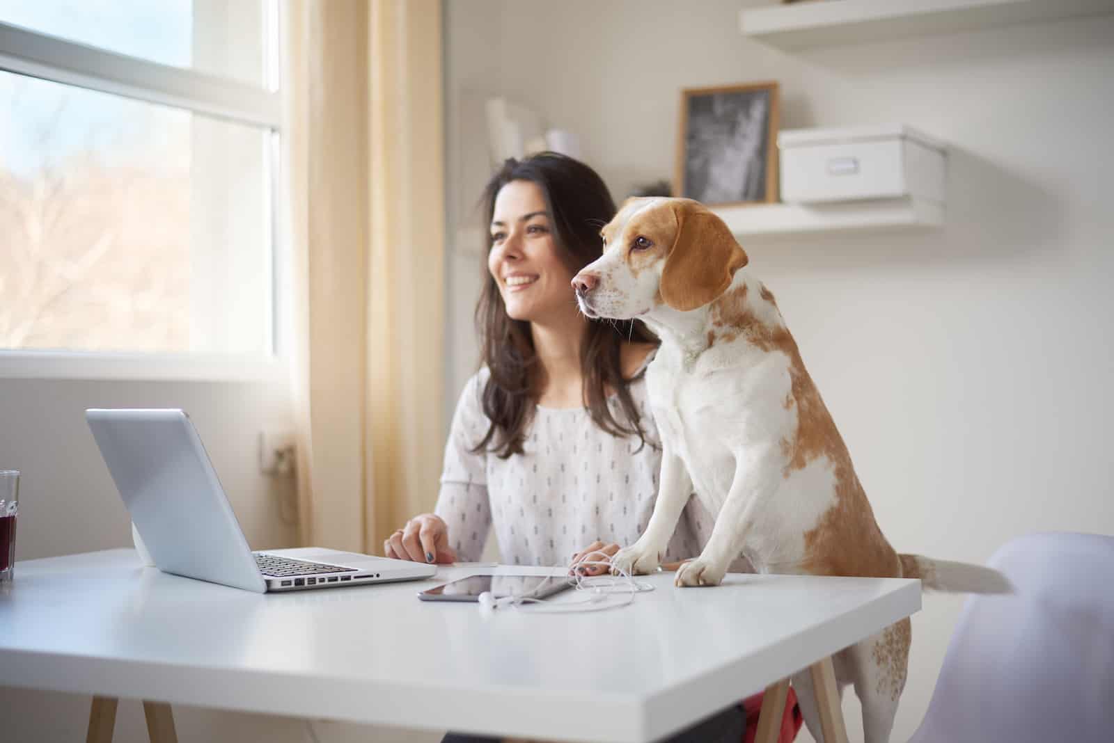 Woman and dog sitting at the computer