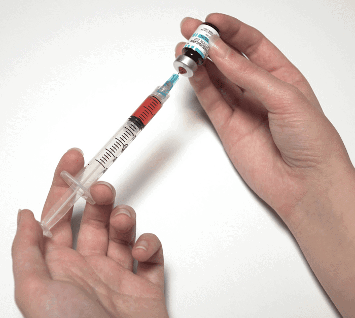 syringe drawing up a vaccine